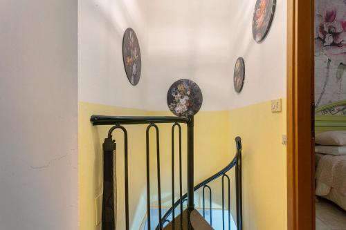 a hallway with plates on the wall and a staircase at Casa Perry - Lago Maggiore in Borgo Ticino