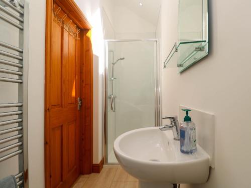 a white sink in a bathroom with a shower at The Coach House in Hayle