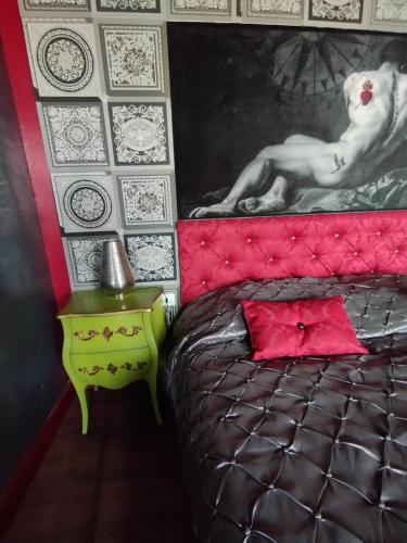 a bedroom with a bed with a pink head board at Le PALAZZO YES in Woël