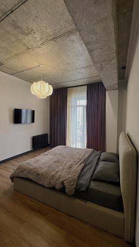 トビリシにあるApartment with big balcony at Didi Dighomiのベッドルーム1室(窓の前に大型ベッド1台付)