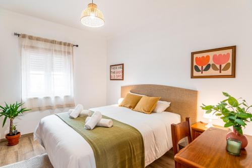 a bedroom with a large bed and a table at DONOTHING HOUSE - GUESTHOUSE - Baleal in Ferrel