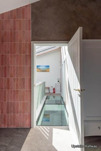 a room with a glass floor and a balcony with a door at The Lost Lobster in North Berwick