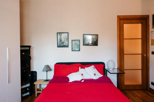 a red bed with two white pillows on it at La Cinciallegra in Val Della Torre