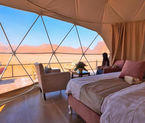 a woman in a tent with a view of the desert at Charlotte luxury camp in Wadi Rum