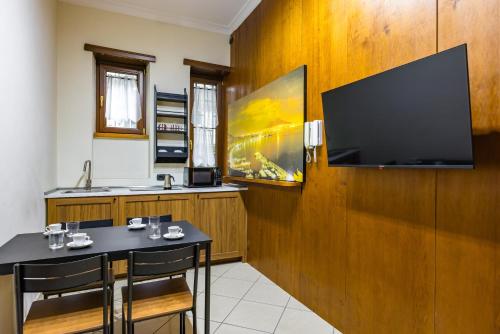 una cucina con tavolo e televisore appeso a un muro di Toledo Bright Apartment by Wonderful Italy a Napoli