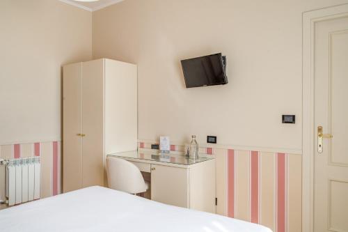 a bedroom with a bed and a desk and a tv on the wall at Hotel Parker - Gruppo BLAM HOTELS in Rome