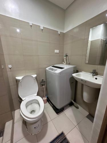 a bathroom with a toilet and a sink at Sea Residence MOA - Chrisdick in Manila