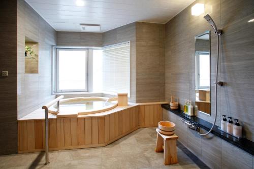 a large bathroom with a tub and a shower at Noboribetsu Grand Hotel in Noboribetsu