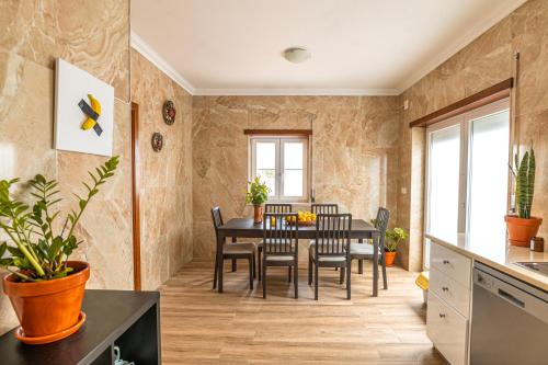 a kitchen and dining room with a table and chairs at DONOTHING HOUSE - GUESTHOUSE - Baleal in Ferrel