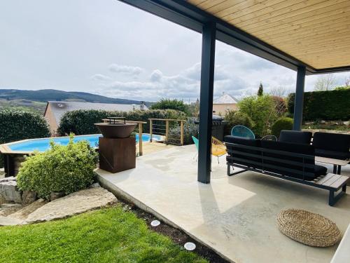 un patio avec un banc et un barbecue et une piscine dans l'établissement La VILLA MADDIE, à Montrozier