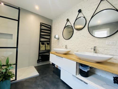 une salle de bain avec deux lavabos et deux miroirs dans l'établissement La VILLA MADDIE, à Montrozier