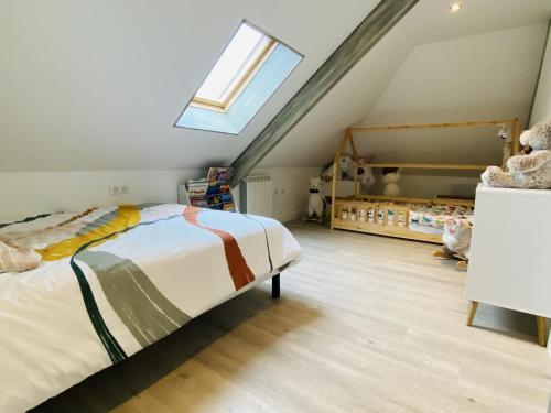 une chambre mansardée avec un lit et une fenêtre dans l'établissement La VILLA MADDIE, à Montrozier