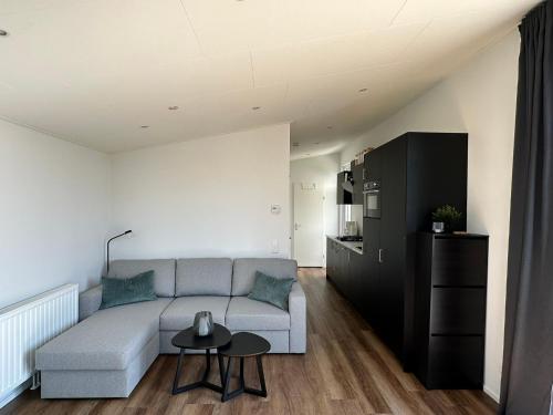 a living room with a couch and a table at In Seenähe - Modernes Chalet im Ferienpark De Veerstal - familienfreundlich! in Lathum