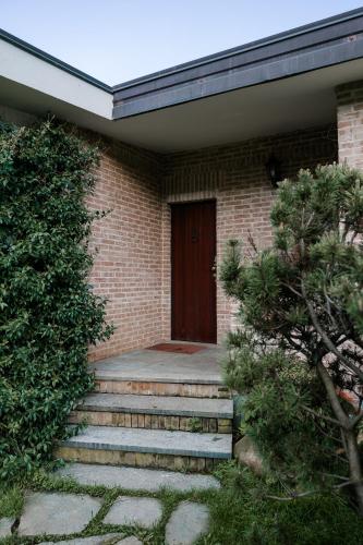 a brick house with stairs leading to a door at La Cinciallegra in Val Della Torre