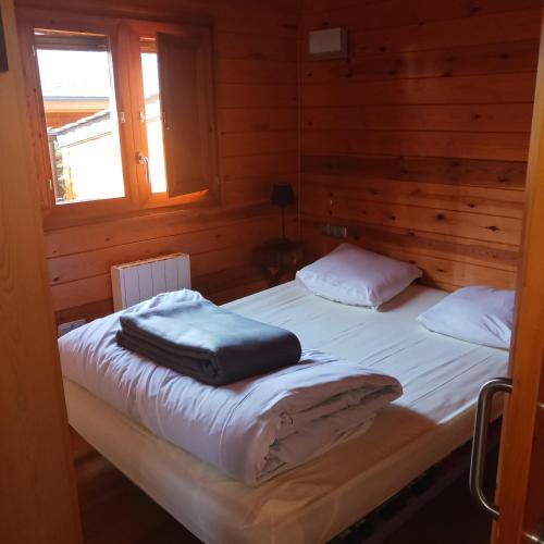 a bedroom with two beds in a wooden cabin at PRL El Pastural in Err