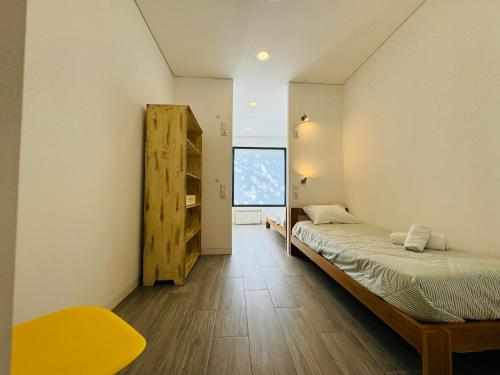 a small bedroom with a bed and a window at Albergue Pilares do Caminho in Marinhas