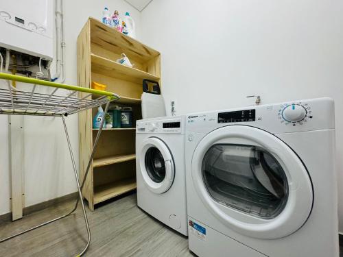 a washing machine in a room with a laundry basket at Albergue Pilares do Caminho in Marinhas