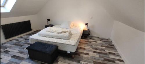 - une chambre avec un lit et un pouf dans l'établissement cocon près de la mer, à Morlaix