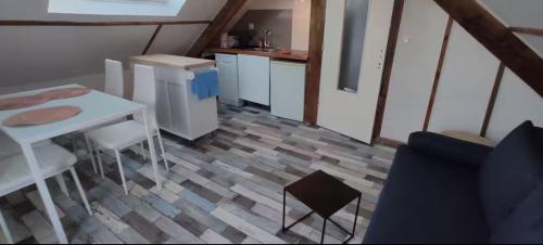 - une cuisine avec une table et une table et des chaises blanches dans l'établissement cocon près de la mer, à Morlaix