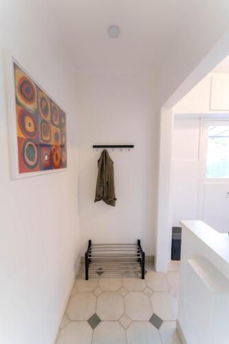 une pièce blanche avec un banc et un tableau dans l'établissement Magnifique rez de jardin Nice Port, à Nice