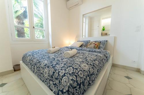 une chambre avec un lit avec une couette bleue et blanche dans l'établissement Magnifique rez de jardin Nice Port, à Nice
