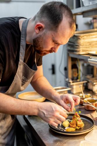 a man preparing a plate of food on a counter at The Boot Inn in Burton upon Trent