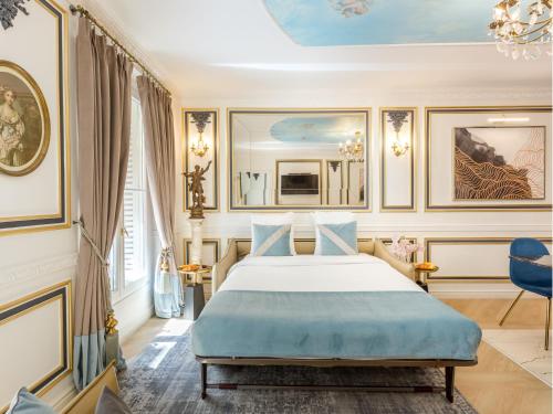 une chambre avec un lit avec une couverture bleue dans l'établissement Merveil - Luxury Suite -Champs Elysees- Ponthieu I, à Paris