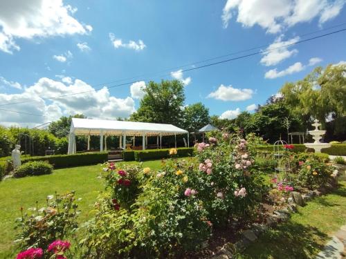 a garden with flowers and a pavilion in the background at Le PALAZZO YES in Woël