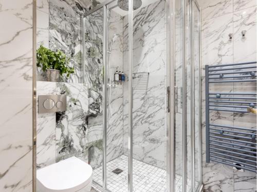 une salle de bain en marbre avec douche et toilettes dans l'établissement Merveil - Luxury Suite -Champs Elysees- Ponthieu I, à Paris