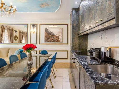 une cuisine avec un comptoir et des chaises bleues dans l'établissement Merveil - Luxury Suite -Champs Elysees- Ponthieu I, à Paris