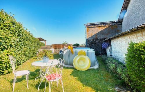 a small yard with a table and chairs in the grass at Awesome Home In Gageac-Et-Rouillac in Gageac-et-Rouillac