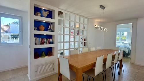 a dining room with a wooden table and chairs at Galo - Private Pool - 8 Guests - Albufeira in Albufeira