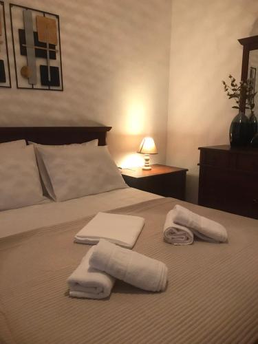 een slaapkamer met een bed met handdoeken erop bij ARIS House in Agia Paraskevi