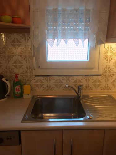 a stainless steel sink in a kitchen with a window at ARIS House in Agia Paraskevi