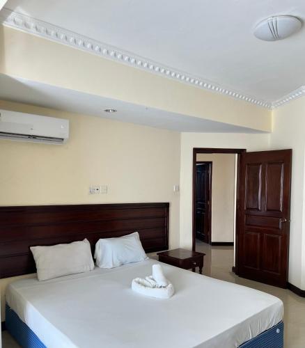 a bedroom with a large bed with white sheets at Sunrise-Nyali, Mombasa in Nyali
