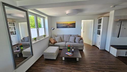 a living room with a couch and a mirror at Ferienwohnung An der Seidewitz in Pirna