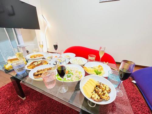 a table with plates of food and glasses of wine at 広島Riverside house第2ひまわり301号室 in Hiroshima