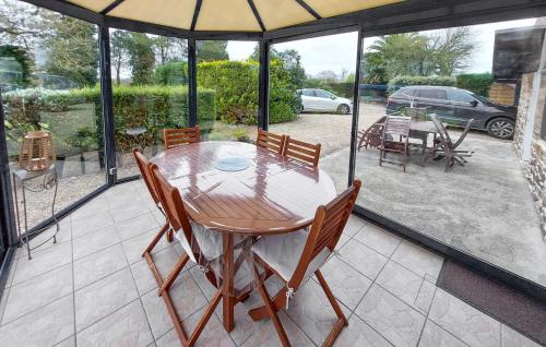 - une table en bois avec des chaises et un parasol sur la terrasse dans l'établissement 2 Bedroom Cozy Home In Plouha, à Plouha