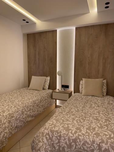 a bedroom with two beds and a table with a lamp at Al amirat front sea only family in Martil
