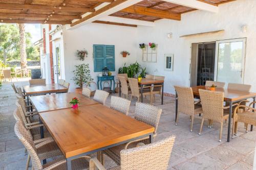 a patio with wooden tables and chairs at Turismo Rural Biniati des Pi in Sant Lluis