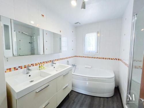 La salle de bains blanche est pourvue de 2 lavabos et de toilettes. dans l'établissement Maison 3 chambres avec piscine à Sanary-sur-Mer, à Sanary-sur-Mer
