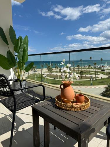 a table on a balcony with a view of the ocean at Al amirat front sea only family in Martil