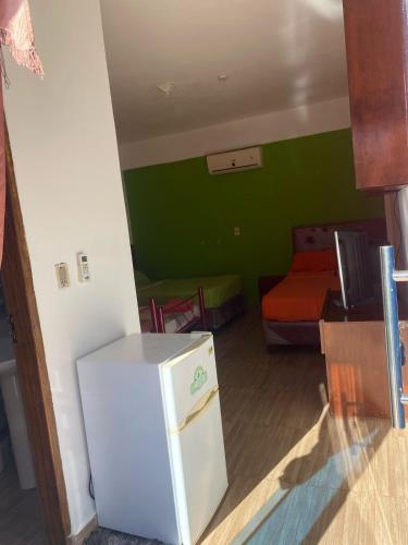 a small kitchen with a refrigerator in a room at Hotel San Expedito in Carmen del Paraná