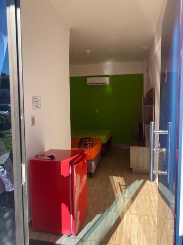 a room with a bed and a green wall at Hotel San Expedito in Carmen del Paraná
