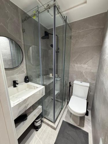 a bathroom with a shower and a toilet and a sink at Al amirat front sea only family in Martil