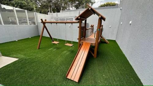 a swing set sitting on top of green grass at R1 - Iguaçu Apt - Centro of Foz in Foz do Iguaçu