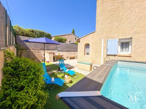 une cour avec une piscine entourée de chaises et d'un parasol dans l'établissement Maison 3 chambres avec piscine à Sanary-sur-Mer, à Sanary-sur-Mer