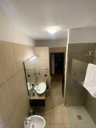 a bathroom with two sinks and a shower at Misani Apartments in Novara