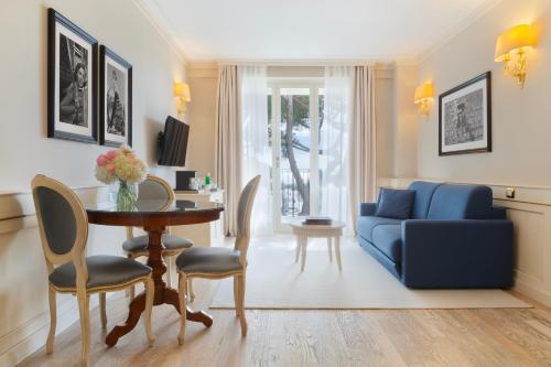 a living room with a blue couch and a table at Grand Hotel Imperiale in Forte dei Marmi