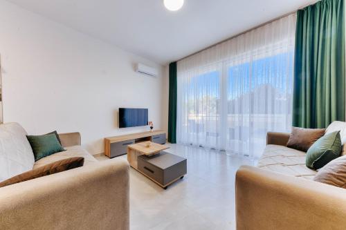 a living room with two couches and a tv at ARA Lux Apartments in Utjeha